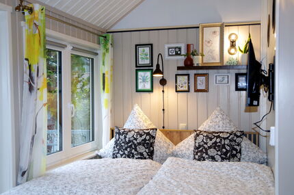 Schlafplatz mit Bett, Leselampen, Bilder und Fernseher